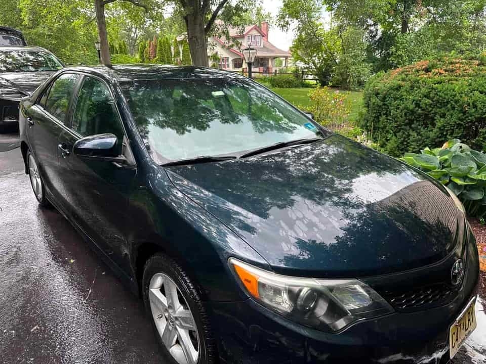 Dark blue Toyota Camry exterior AFTER full detail by Detail Jockey — clean, glossy paint reflecting trees, Flemington NJ