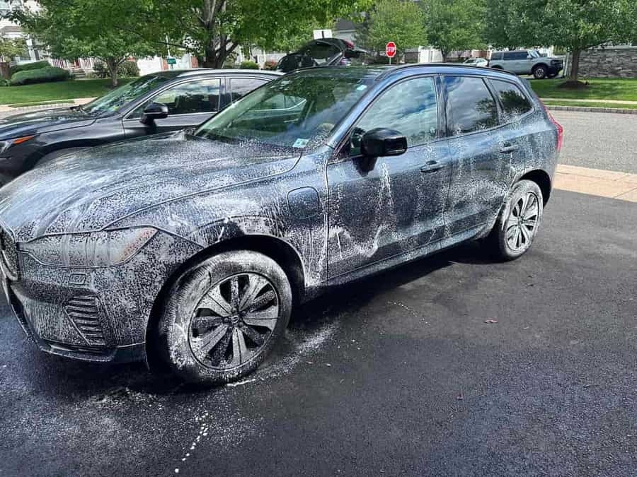 Blue Volvo XC60 covered in iron decontamination foam during exterior detail — pre-wash stage, NJ