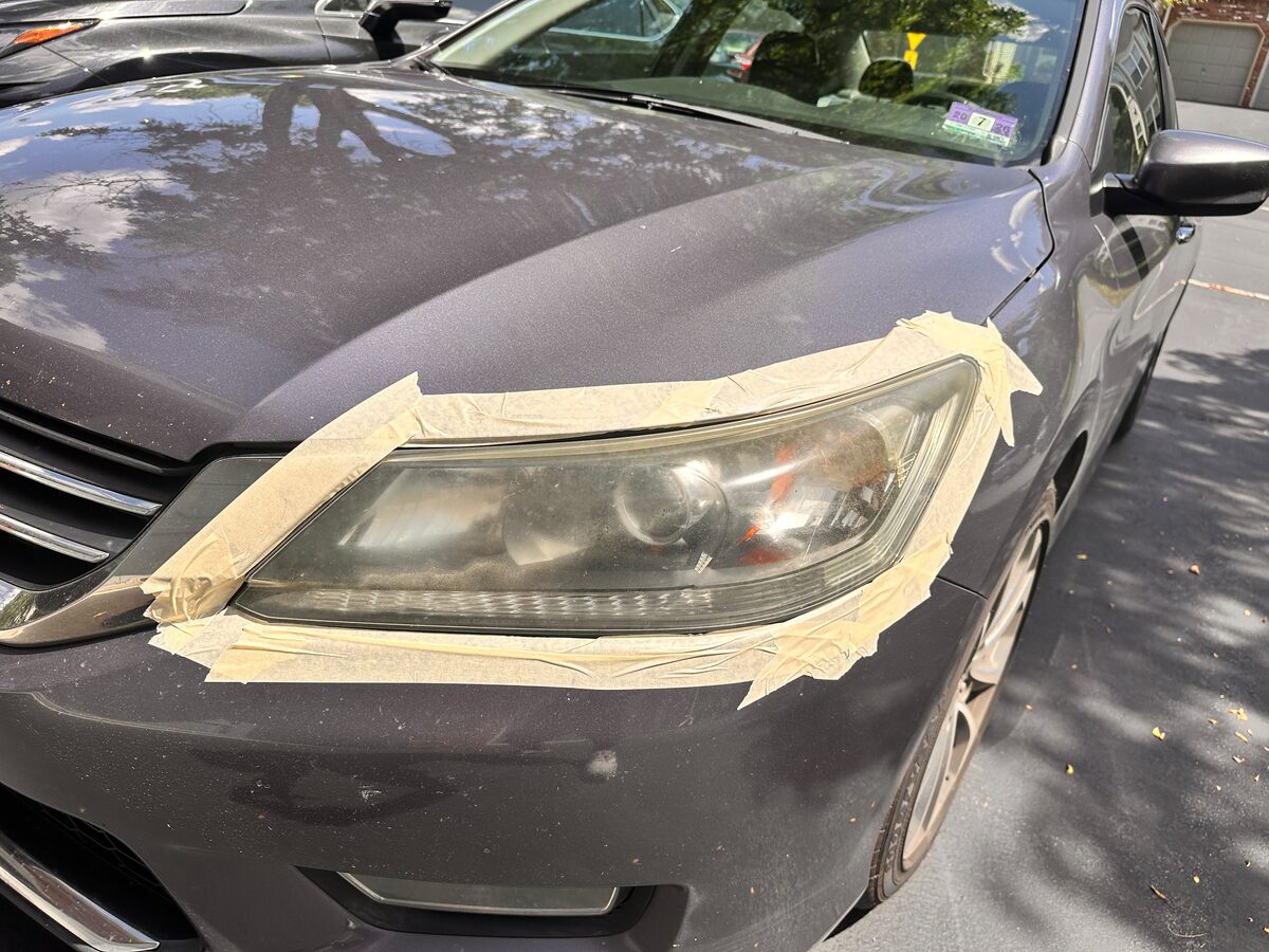 Before headlight restoration — oxidized, foggy Honda Accord headlight lens with masking tape for wet sanding, Flemington NJ