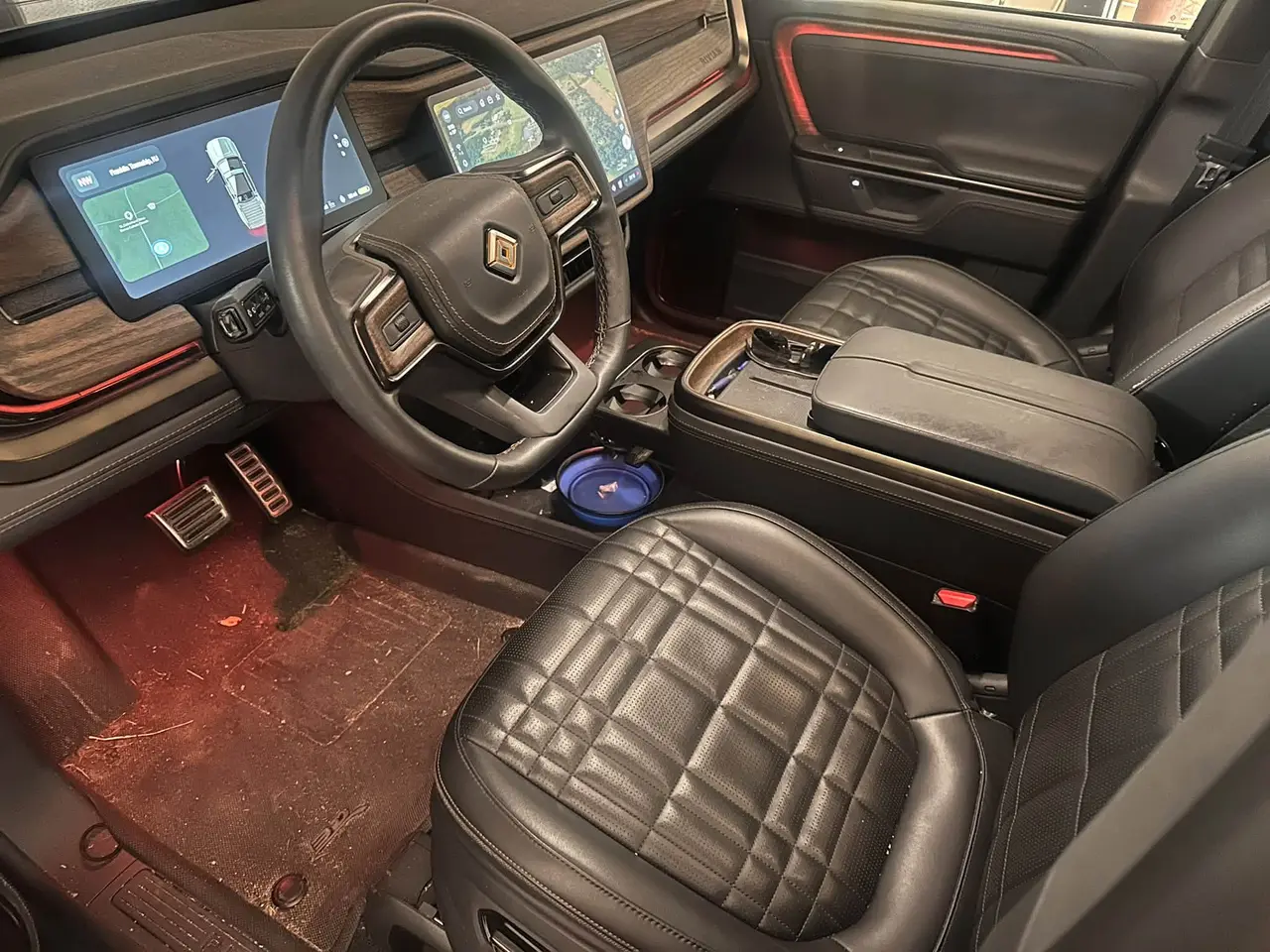 Rivian R1T BEFORE interior detail by Detail Jockey — dirty driver floor carpet, dusty armrest and console, NJ